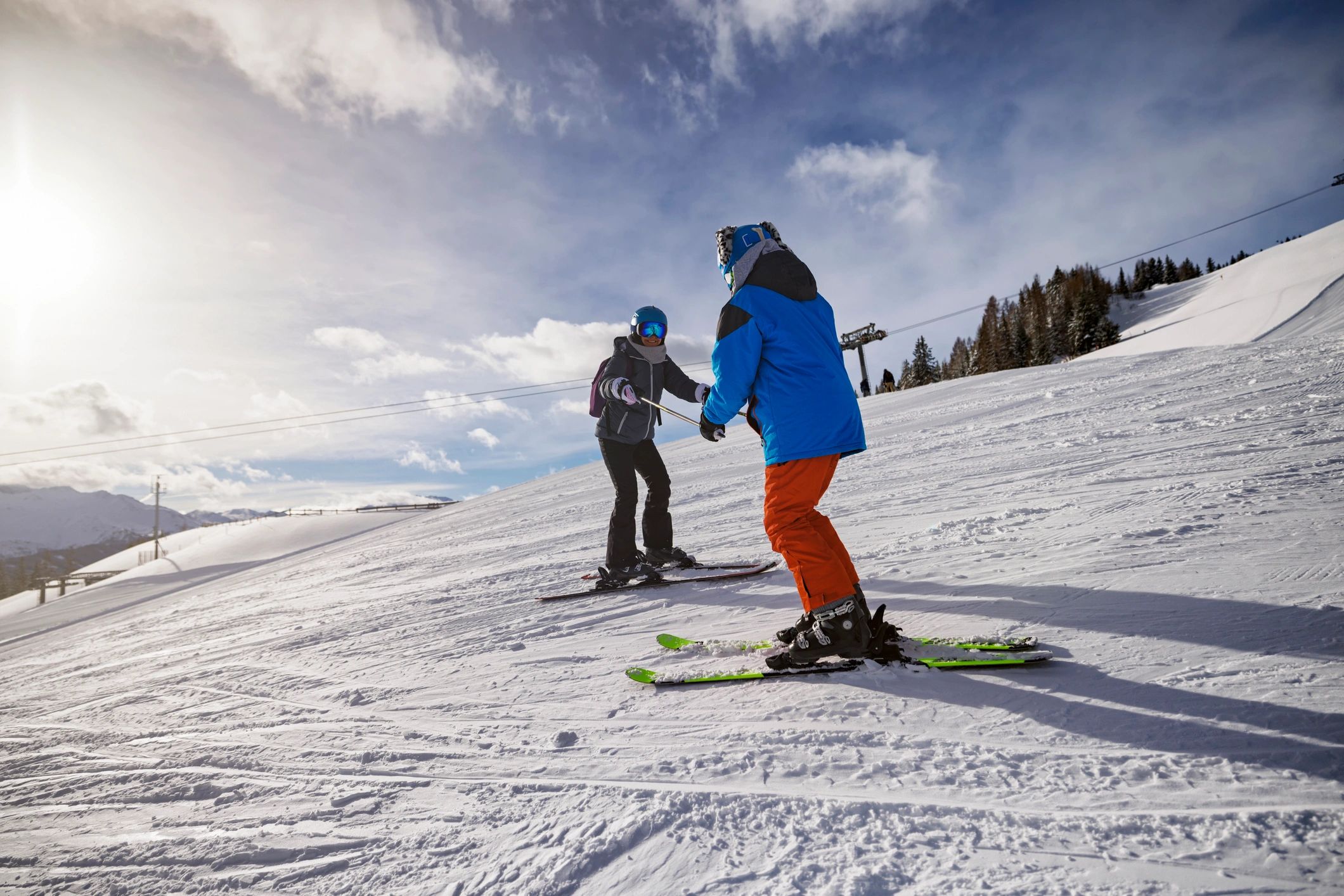 Instructor coaching a skier on a sunny slope