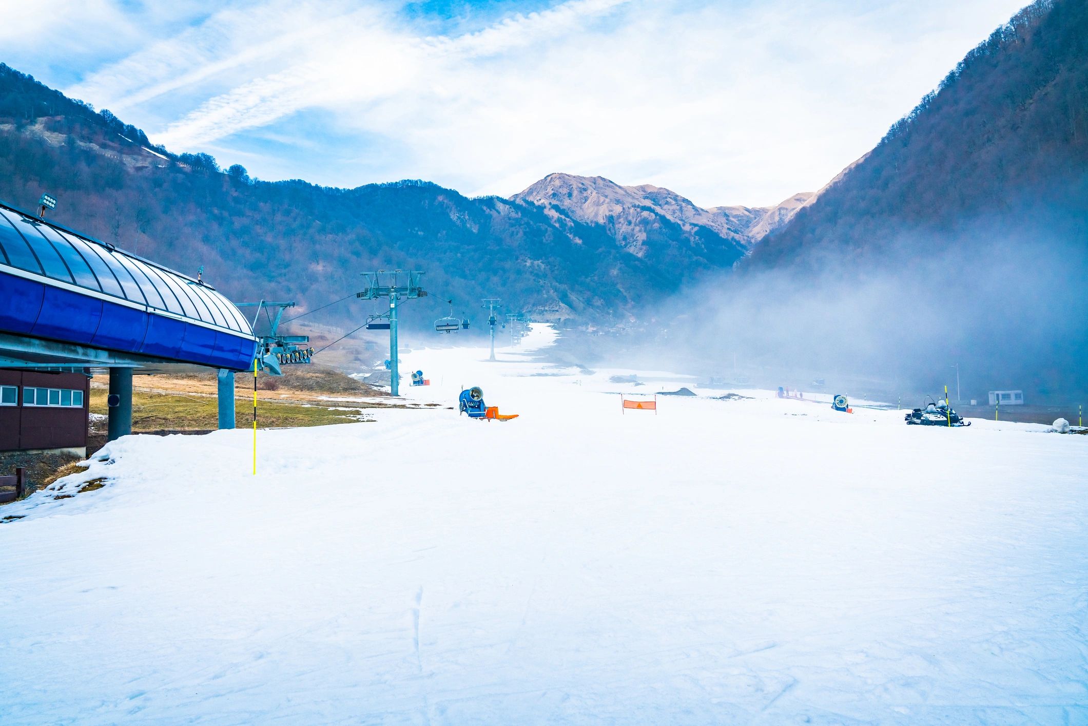 Wide ski slope with low mist over the snow