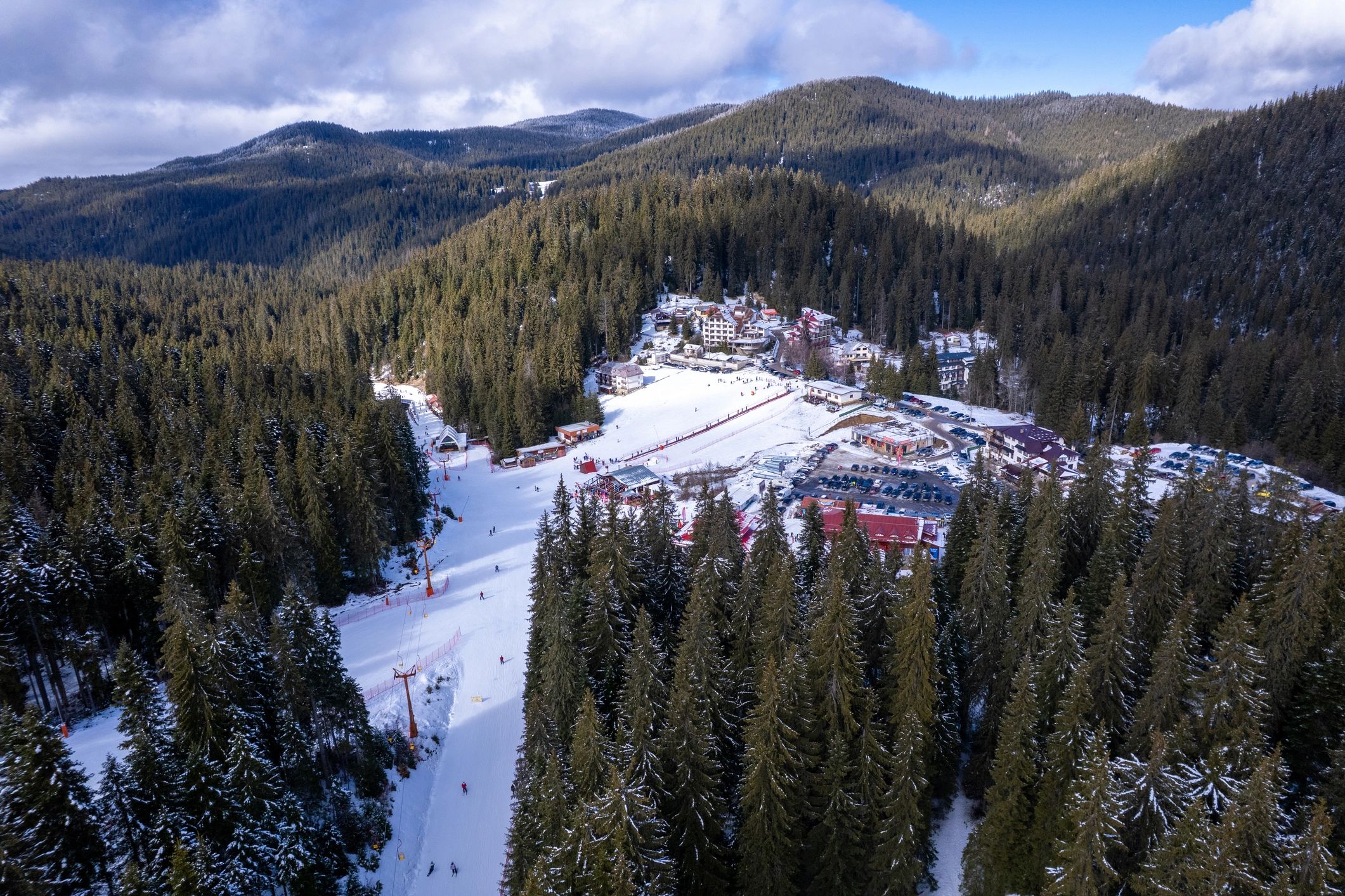 Aerial view of a ski slope and resort buildings on a sunny winter day